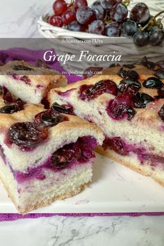 a close up of a piece of cake on a plate with powdered sugar and cherries