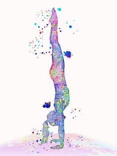 a person doing a handstand in the air with colorful paint splatters