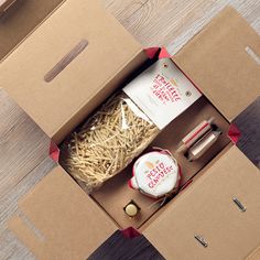 an open box with some items in it on a wooden floor next to other boxes