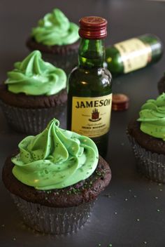 cupcakes with green frosting next to a bottle of jameson