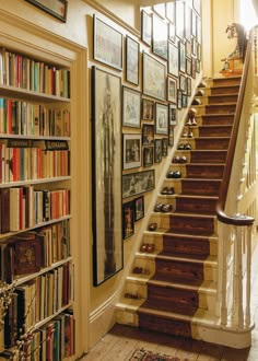 a staircase with bookshelves and pictures on the wall