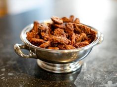 a metal bowl filled with meat on top of a table