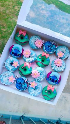 a box filled with blue and green decorated cupcakes