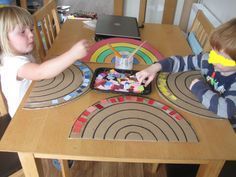 two children sitting at a table playing with toys