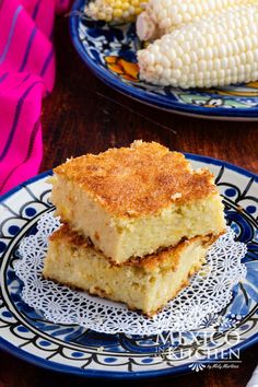 two plates with corn on the cob and another plate that has some food on it