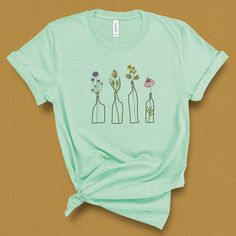 This botanical wildflower shirt with a vintage feel was inspired by my neighbors flowers in the window and Spring super blooms. This graphic tee is the perfect gift for gardeners, moms, and spring birthdays, eternal blooms for special days. DETAILS This Beautiful graphic t-shirt is made of 49% to 100% combed and ring-spun cotton and is very soft and comfortable to wear. Check the size card for specific fabrications per color. We use DTG technology and eco friendly inks allowing us to produce vib Wildflower Shirt, Modern Flowers, Botanical Shirt, Gardening Shirts, Flower Graphic, Modern Flower, Flower Shirt, Spring Shirts, Tees For Women