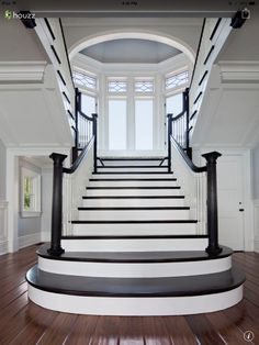 an empty staircase in a house with wood floors and white walls, leading to the second floor