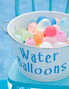 a bucket filled with balloons sitting on top of a blue chair