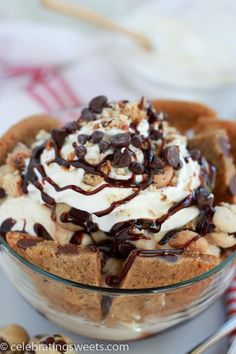 an ice cream sundae with chocolate chips and whipped cream on top in a glass bowl