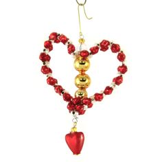 a red and gold beaded heart ornament hanging from a hook on a white background