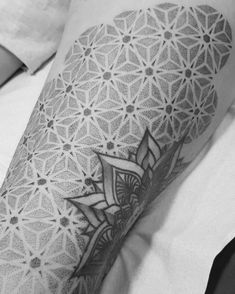 a black and white photo of a person's arm with a geometric pattern on it