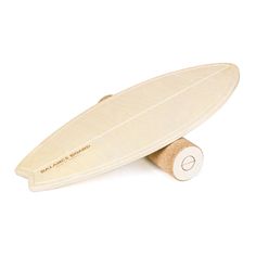 a wooden surfboard is sitting on top of a roll of toilet paper and it's cover