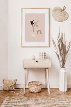 a living room with a table, plant and pictures hanging on the wall above it