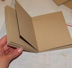 a person is holding some brown paper on a table