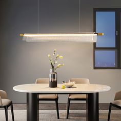 a dining room table with chairs and a chandelier hanging over it, in front of a window