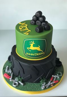 a green and black cake with the john deer logo on it's bottom tier