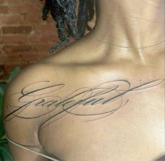 the back of a woman's shoulder with some writing on it