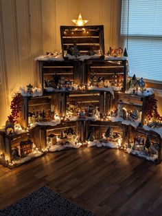 a christmas tree made out of wooden crates with lights on them and decorations around it