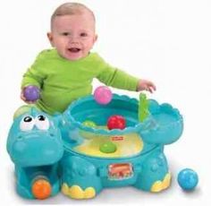 a baby in green shirt playing with toys