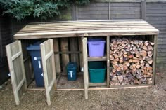 there is a firewood shed with several different types of logs in the bins