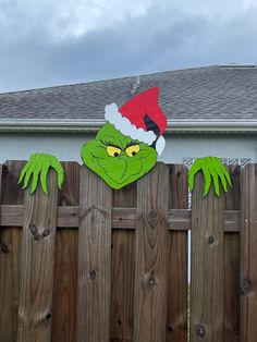 the grin face has been painted on this wooden fence, and it looks like he's wearing a santa hat