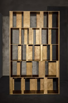 a wooden book shelf with several compartments on each side and one section missing from the wall