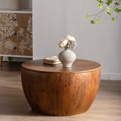 a vase with flowers sitting on top of a wooden table