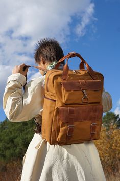 This handmade leather backpack suites men and women. It is modern and has fashionable design. It is suitable for caring it around every day in any weather and season of the year. This canvas backpack is made out of real high-quality Italian leather of two kinds and canvas (very reliable natural material) produced in the Italy. Inside there is one division. Also there is one big pocket that will fit your laptop and a velcro to secure it. Two big pockets right by it for smaller belongings. On the other side inside of the backpack there is a big pocket and smaller pocket with the zipper for valuable belongings. Outside of the backpack on the front side there are two big pocket. The lower one is quite capacious and closes with two reliable buckles for the secure storage on your belonging. The Modern Brown Backpack For Outdoor, Modern Brown Leather Backpack For Outdoor, Brown Leather Functional Backpack, Modern Brown Outdoor Backpack, Leather Backpack With Pockets For On-the-go, Leather Backpack With Anti-theft Pocket, Brown Leather Backpack With Anti-theft Pocket, Brown Leather Rectangular Backpack With Anti-theft Pocket, Handmade Leather Backpack