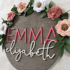 a wooden sign with flowers on it that says,'emma lighten '