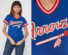 This vintage 1980s Wilson Arrows baseball jersey features a vibrant blue color with red and white striped trim. The front showcases the "Arrows" team name and logo, while the back displays the number 24. Please see measurements and condition below. Every garment we sell is authentic vintage and one-of-a-kind! You will receive the exact item photographed. Condition: Very good vintage with light general wear. Size label: Labelled Youth Medium Best fits: women's xs Tag: Wilson Material: Feels like Jersey Vintage, Blue Jersey, Striped Short, Athletic Shirts, Size Label, Vibrant Blue, Red And White Stripes, Baseball Jersey, Baseball Jerseys