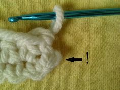 the crochet is being worked on by someone using a blue handled knitting needle