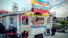 a small restaurant with many signs on the front and side of it's building