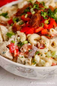 a white bowl filled with macaroni salad on top of a table