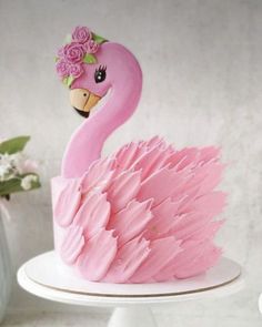 a pink cake decorated with a flamingo and flowers