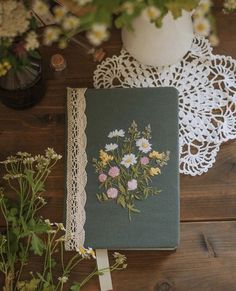 a book on a table with flowers and lace