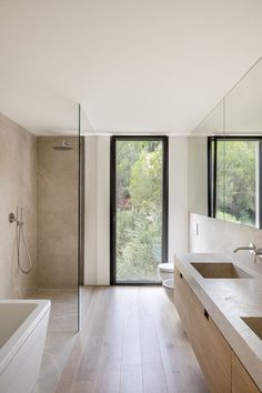 a large bathroom with two sinks and a walk - in shower next to a bathtub