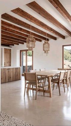 a large dining room with wooden beams and white walls