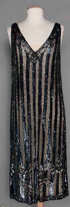 SEQUINED FLAPPER DRESS, 1920s Black tulle, 1" vertical bands of pewter sequins w/ 2 rows of bugle beads between, beads & sequins in floral pattern near hem, sleeveless, V neck, B 34"-36", H 36"-40", L 44", (few trim losses) very good. Flapper Dress 1920s, 20s Dresses, 1920 Fashion, 20s Fashion, 1920s Dress, Antique Dress, Vintage Gowns, Black Tulle, Bugle Beads