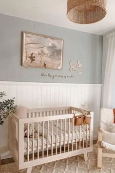 a baby's room with a crib, rocking chair and pictures on the wall