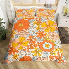 a bed with an orange and blue flower pattern on it