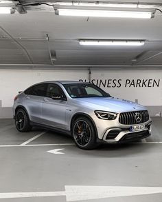 a silver car parked in a parking garage next to a sign that says business parken