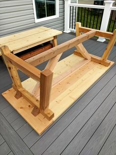 a wooden bench sitting on top of a porch next to a building with a window