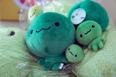 two green stuffed animals laying on top of each other