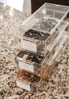 three clear drawers are stacked on top of each other in the middle of a marble countertop