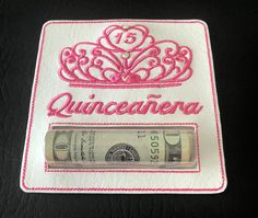 a piece of paper with the word quinceanera written on it and a roll of money in front of it