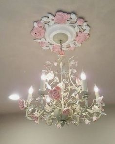 a chandelier hanging from the ceiling with roses on it