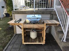 an outdoor bbq grill is set up on the back porch with a propane tank