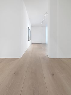 an empty room with white walls and wood flooring is seen in this image from the inside