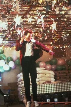 a man standing on top of a stage with stars hanging from the ceiling above him