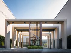 an entrance to a building with a sculpture in the center and bushes on either side